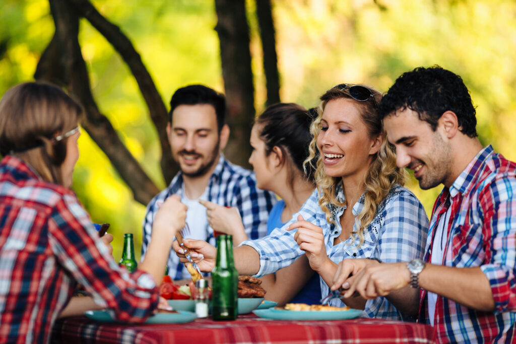 Group of happy people eating food outdoors
